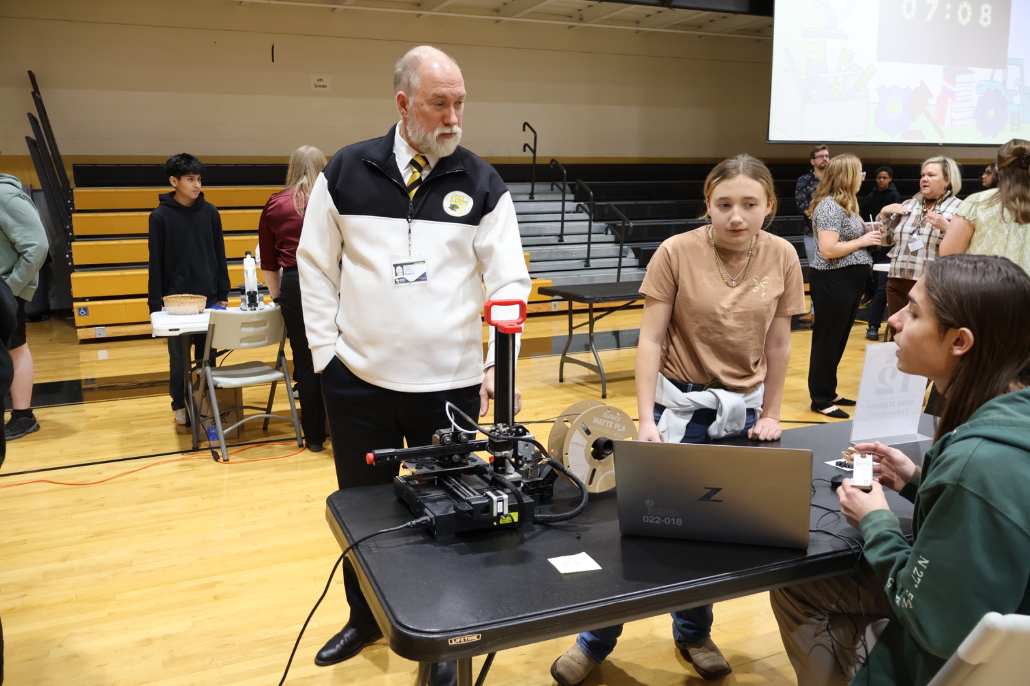 Casey Jaynes talking with students at a technology and innovation showcase